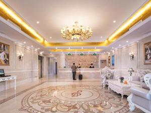 徐州Vienna Hotel Xuzhou Junsheng Plaza Benteng Avenue Metro Station的站在一个大房间,有吊灯的人