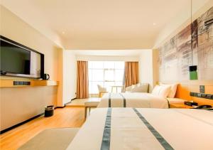 海口City Comfort Inn Haikou Zhongjie Road Walking Street的酒店客房设有两张床和一台平面电视。