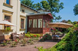 克拉科夫尤帕纳科吉托酒店的一座带庭院和遮阳伞的房子