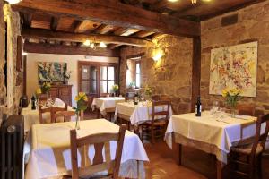 El RoyoLa Casona de El Royo的餐厅配有桌椅和白色桌布