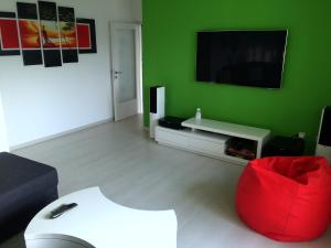 里耶卡Apartment Alan的绿色的客厅配有红色椅子和电视