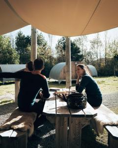 约尔珀兰Hikers Camp, Part of Preikestolen BaseCamp的一群人坐在帐篷下的桌子上