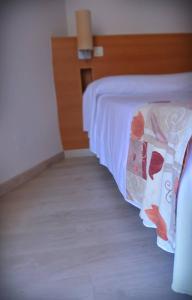 卡拉德费斯特拉特厄洛恩酒店的一间卧室配有一张带白色床罩的床