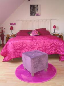 Gevry拉伯纳迪艾尔住宿加早餐旅馆的卧室配有粉红色的床和紫色棉被