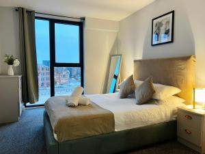 伯明翰Sleek City Centre Suite with FREE Netflix & Parking的一间卧室设有一张大床和大窗户