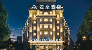 苏州Atour Hotel Suzhou Campus Town Yuexi Metro Station的一座酒店大楼,上面有标志