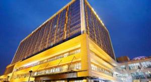 成都Metropolo Hotel Chengdu Wuhou Wanda Plaza的尖顶高高的黄色建筑