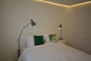 多列毛利诺斯Nogalera Boutique Apartment的卧室配有带两盏灯的白色床