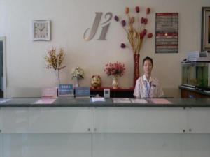 济南Jinjiang Inn Jinan Shimao Kuanhouli Quancheng Road的站在商店柜台后面的人