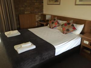 黄金海岸玛拉汽车旅馆的一张位于酒店客房的床位,配有毛巾