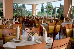 斯楚雅萨琳内拉公寓生物能源度假酒店的餐厅设有白色的桌椅和窗户。