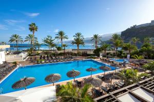 拉克鲁斯索尔科斯塔亚特兰蒂斯特内里费酒店的享有带椅子和遮阳伞的度假村的游泳池景致