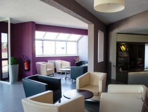 加来HECO Calais Centre-Gare的餐厅设有白色的桌椅和紫色的墙壁