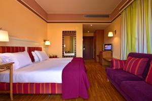 辛特拉辛特拉佩斯塔纳高尔夫SPA度假酒店的酒店客房设有一张大床和一张沙发。