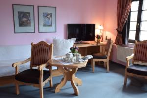 伯根兰德豪斯马力恩斯丁酒店的客厅配有桌椅和书桌。