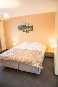 穆斯特韦埃Ankur Hotell的一间卧室配有一张带两张桌子和两盏灯的床。