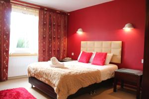 埃尔森汉姆得萨利斯伦敦斯坦斯特德酒店的卧室设有红色的墙壁和一张带粉红色枕头的床