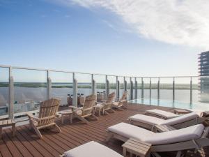 罗萨里奥波多黎各北设计酒店 的大楼内带椅子和游泳池的阳台