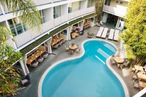 洛杉矶Avalon Hotel Beverly Hills, a Member of Design Hotels的享有酒店游泳池的顶部景致,设有桌椅