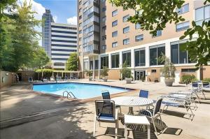 亚特兰大ATL Downtown 2BR King Bed Free Parking LM1702的大楼前带桌椅的游泳池