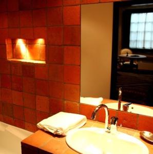 Ladoix Serrigny拉都瓦庄园酒店的浴室配有盥洗盆、镜子和浴缸