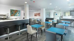 Novedrate布鲁9酒店的一间设有蓝色桌椅和柜台的餐厅