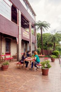 肯图巴Katoomba Mountain Lodge的三人坐在大楼外的桌子上