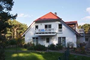蒂索Sommerhaus Thiessow的带阳台和庭院的白色房屋
