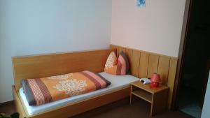 GeyerPension und Berggasthaus Kapellenstein的一张带枕头的木床和一张桌子