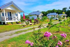 Kuala PenyuBadungun Seaside View的院子里一排鲜花的房子