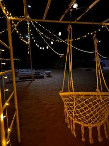 Al WāşilBidiya Dunes camp عزبة بدية ديونز的夜晚在海滩上帐篷上挂的篮子