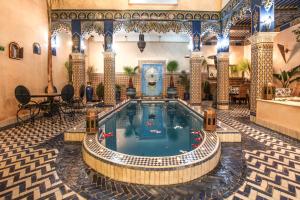 马拉喀什普卡摩洛哥传统庭院住宅的酒店大堂中央的游泳池