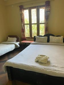 索拉哈Tara guesthouse - Sauraha,Chitwan的一间卧室配有两张床,并备有浴袍