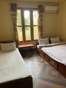 索拉哈Tara guesthouse - Sauraha,Chitwan的客房设有两张床和窗户。