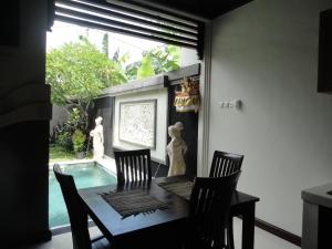坎古艾力特巴厘岛别墅的餐桌、四把椅子和游泳池