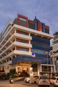 坤甸坤甸加亚马达酒店的酒店大楼前面设有停车场
