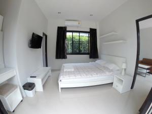 北芭堤雅芭堤雅菲尔泰克斯公寓的白色的卧室设有床和窗户