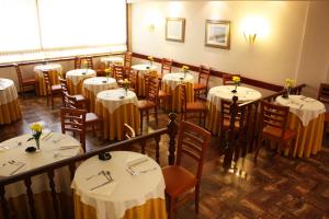 波尔图总督酒店的餐厅配有桌椅和白色的桌布