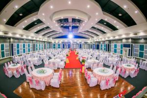 呵叻拉亚大酒店的宴会厅配有白色桌子和粉红色椅子