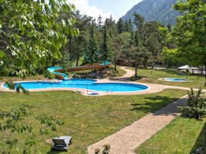 格吕施格鲁施酒店的树木繁茂的公园里的一个大型游泳池