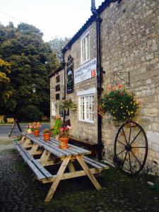 里彭The Bull Inn West Tanfield的大楼前的木餐桌