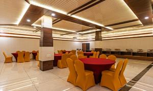 Manī MājraHotel Chandigarh Grand and Banquet的一间会议室,里面配有桌子和黄色椅子