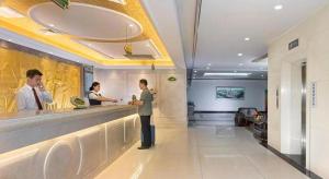 济南Vienna Hotel Jinan Quancheng Road Daming Lake的站在餐厅柜台上的人