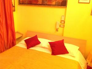 福贾Bed & Breakfast Federico II的一间卧室配有一张带两个红色枕头的床