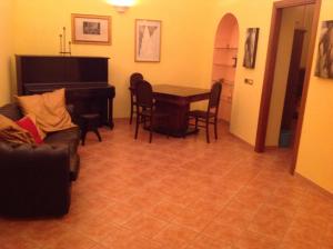 福贾Bed & Breakfast Federico II的客厅配有钢琴、桌子和椅子