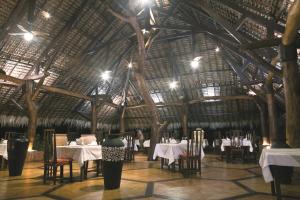 Ambaro拉文萨拉疗养酒店的一间带桌椅和大型木制天花板的餐厅