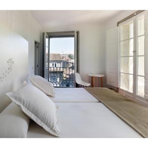 圣地亚哥－德孔波斯特拉阿尔塔米拉庄园酒店的白色的卧室设有一张大床和一个窗户