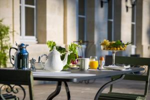 莱奥尼昂Château Le Pape B&B的茶壶和一碗水果的桌子