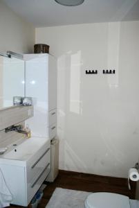格丁尼亚Homestay Kapitańska 9的白色的浴室设有水槽和卫生间。