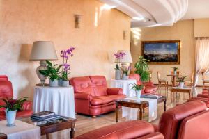 内图诺阿斯图拉宫酒店的一间设有红色椅子和桌子的等候室